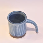 Blue ceramic mug on a light beige background