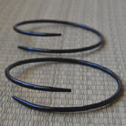 Coiled black metal rod on a textured surface