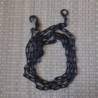Black chain with hooks on a textured beige background