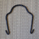 Black metal hook on a textured beige background