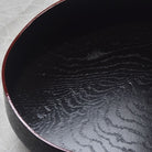 Close-up of a black tray with textured surface on a light gray background
