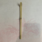 Gold-colored tool on a textured light gray background