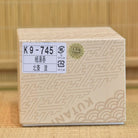 Wooden block with a label and 'KUTAN' branding on a bamboo background