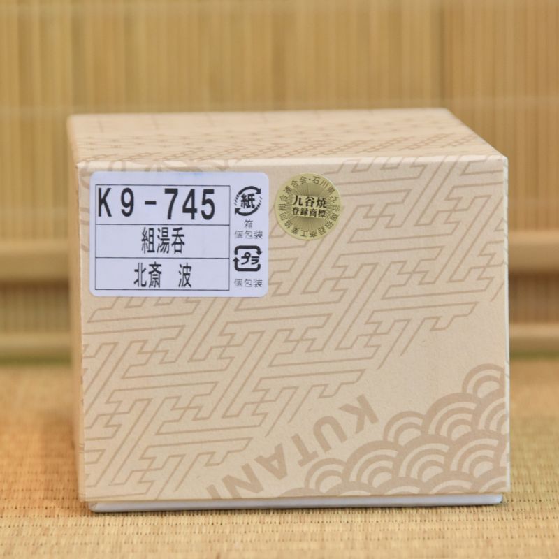 Wooden block with a label and 'KUTAN' branding on a bamboo background