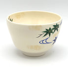 Reverse view of the Aomomiji Kyo Ware chawan showing a smaller green maple leaf and flowing water motif on the ivory glaze