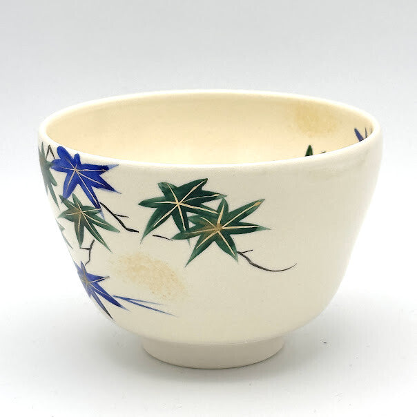 Side view of the Aomomiji Kyo Ware matcha bowl showing hand-painted green and blue maple leaves with flowing water