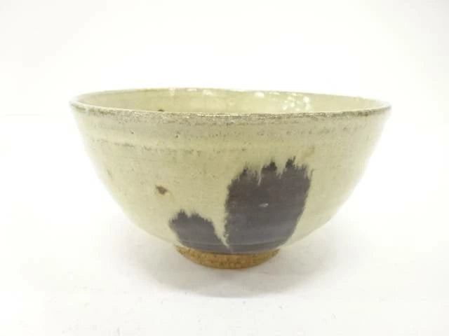 Back view of the pre-owned matcha bowl showing its restrained cream and muted green glaze, rounded form, and exposed clay foot.