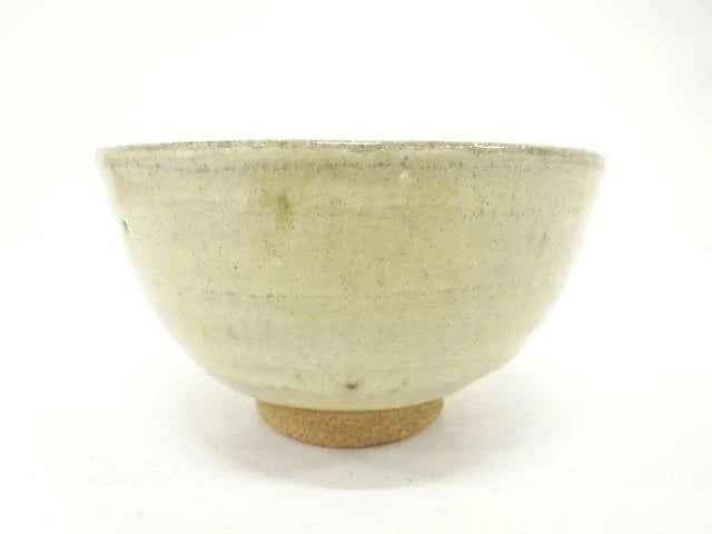 Back view of the pre-owned matcha bowl showing its restrained cream and muted green glaze, rounded form, and exposed clay foot.