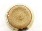 Underside view of the Spotted Karatsu matcha bowl showing the broad unglazed foot, warm clay tones, and dark glaze accent near the edge.