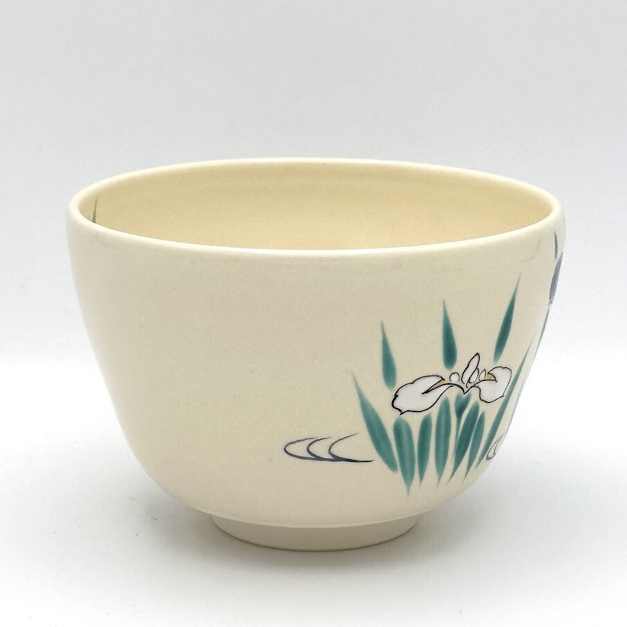 Side view of the Kyo Ware chawan highlighting hand-painted Japanese iris blossoms and green leaves on the ivory glaze