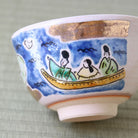 Side view of the Japanese matcha bowl showing figures in a boat beneath the blue starry sky design