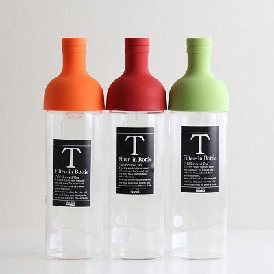 Three bottles with colored caps and clear bodies on a white background