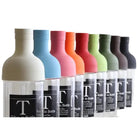 Row of colorful bottles with visible labels on a light background
