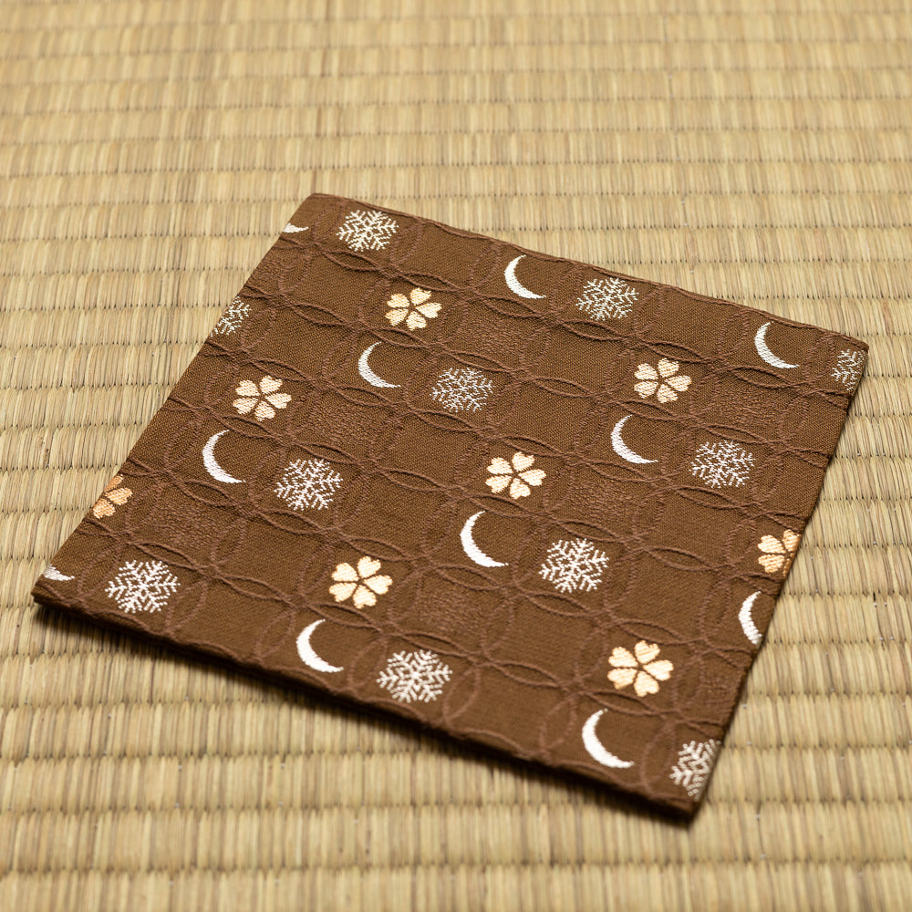 Angled view of the hand-sewn brown Chitose-bon kobukusa resting on a tatami surface.
