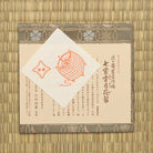 Khaki green Chitose-bon kobukusa displayed with its paper product labels on tatami.