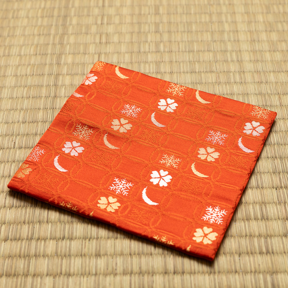 Angled view of the hand-sewn red Chitose-bon kobukusa resting on a tatami surface.