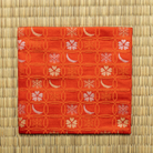 Red Chitose-bon kobukusa by Kitamura Tokusai featuring the Shippo Setsugekka pattern, displayed flat on tatami.