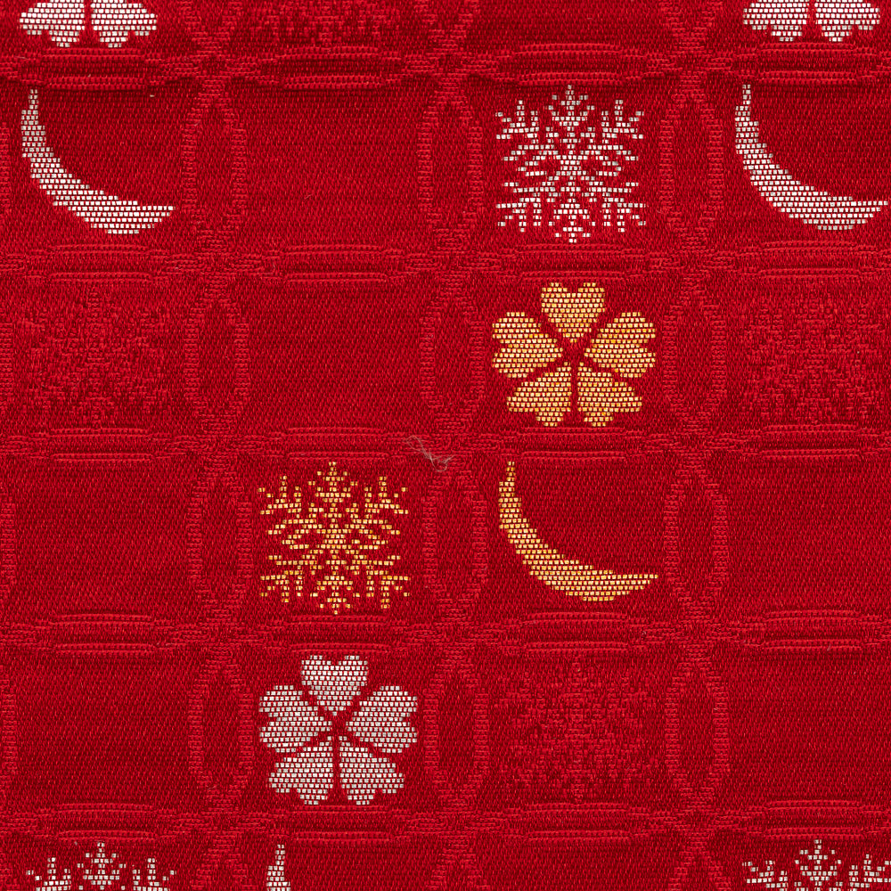 Close-up of wine red Nishijin silk brocade with overlapping shippo circles, snow crystals, crescent moons, and flowers.