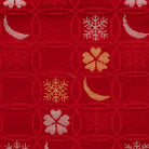 Close-up of wine red Nishijin silk brocade with overlapping shippo circles, snow crystals, crescent moons, and flowers.