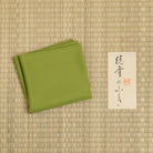 Choji Moss Green silk fukusa displayed on tatami with Kitamura Tokusai label