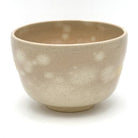 Reverse view of the Choju-Giga Kyo Ware chawan showing its softly speckled beige glaze and subtle hand-painted detail