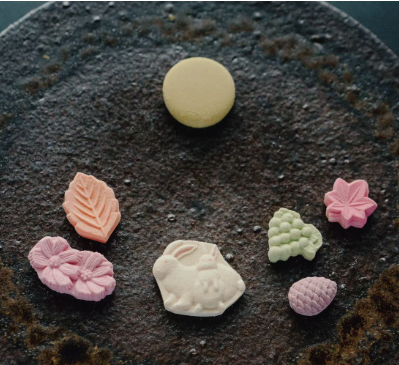 Assorted colorful candy pieces on a textured dark surface