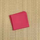 Traditional kurenai crimson red silk fukusa by Kitamura Tokusai on tatami for Chanoyu practice
