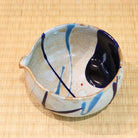 Angled top view of the Tamba Ware katakuchi bowl showing its pouring lip and contrasting navy, light blue, and ivory interior glaze.