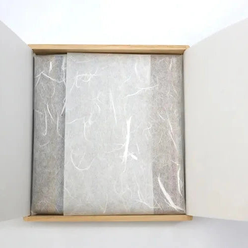 Open box containing a folded piece of fabric on a white background