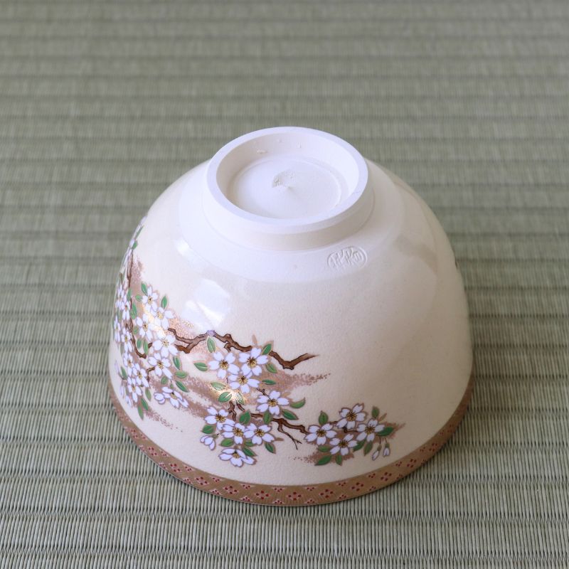 Underside view of the Eika Miyaji Satsuma-style matcha bowl showing its ceramic foot and wraparound cherry blossom decoration