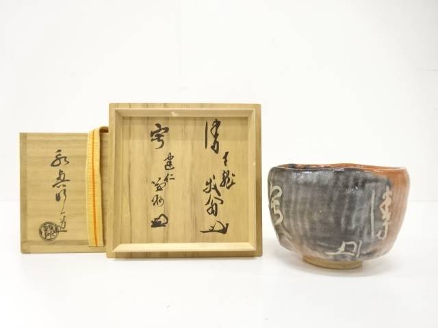 Pre-owned Eiko Meido Raku matcha bowl with smoky charcoal and ember-orange glaze displayed beside its inscribed wooden storage box components.