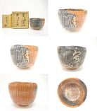 Multiple views of the pre-owned Mandokoro Kiln matcha bowl showing its charcoal and orange glaze, rounded form, interior, underside, and brush decoration.