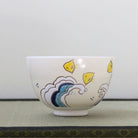 Side view of the Eishin Kato Nami Chidori chawan showing yellow plovers above layered blue and gray stylized waves