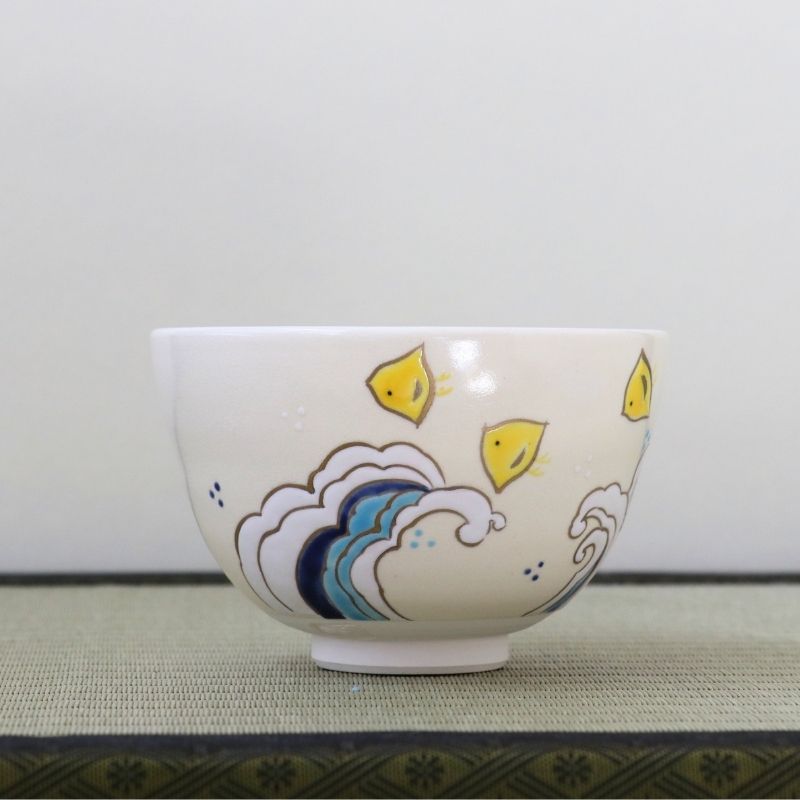 Side view of the Eishin Kato Nami Chidori chawan showing yellow plovers above layered blue and gray stylized waves