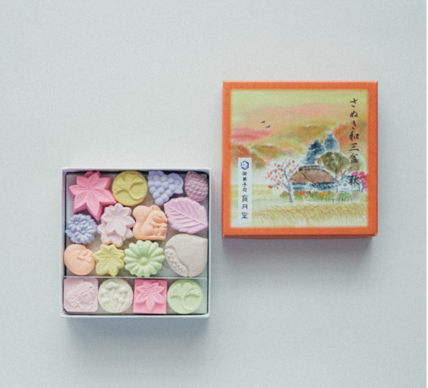 Box of colorful higashi with a decorative lid on a light gray background