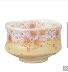Front view of a hand-painted Kutani Ware matcha bowl covered with pink cherry blossoms, gold leaf accents, and fine gold outlines on a warm ivory glaze.