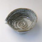 Top view of the gray and white katakuchi matcha bowl showing its pointed spout and spiral glaze pattern inside.