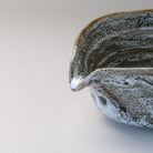 Close-up of the pouring spout and layered gray, white, and charcoal glaze on the Mino Ware katakuchi matcha bowl.