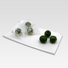 Green candies on a white tray with a white background