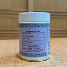 Container of Gyokuro green tea with label on a wooden surface