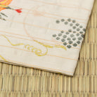 Angled view of Hanakuidori Budoukarakusa Kinran Kobukusa showing elegant flower bird and grape arabesque motifs woven in Kyoto Nishijin silk.
