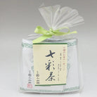 Packaged product with a green ribbon and label on a gray background