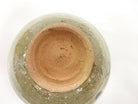 Underside view of the pre-owned matcha bowl showing the circular foot ring, exposed warm clay, and glaze surrounding the base.