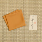 Orange silk fukusa with protective paper sleeve for Japanese Tea Ceremony