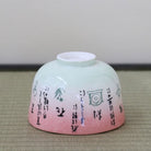 Underside view of the Kagetsu Kiln Rikyu Shichisoku matcha bowl showing its ceramic foot and calligraphy continuing around the pink and pale green exterior