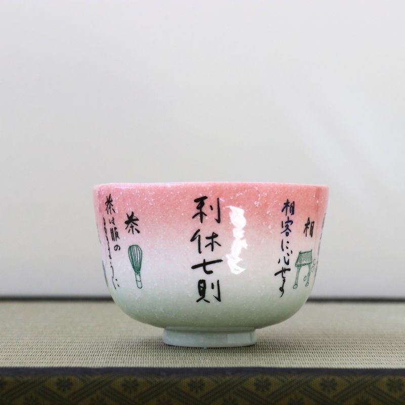 Kagetsu Kiln matcha bowl featuring Rikyu Shichisoku, Sen no Rikyu’s Seven Rules of Tea, with Japanese calligraphy on a pink and pale green glaze