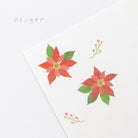 Two red poinsettia flowers with green leaves on a white background