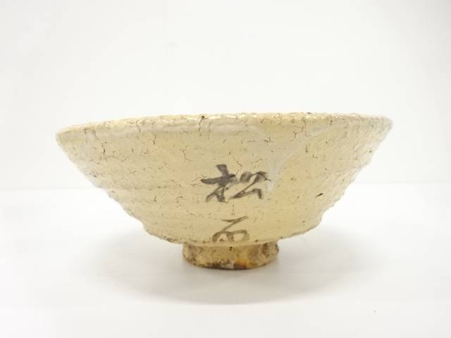 Right angled view of the pre-owned matcha bowl showing its gently flared form, horizontal surface texture, and dark painted accent near the foot.