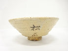 Right angled view of the pre-owned matcha bowl showing its gently flared form, horizontal surface texture, and dark painted accent near the foot.