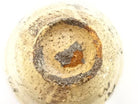 Underside view of the Kaneko Sofu chawan showing the circular foot, exposed clay, dark firing marks, and reddish kiln variation.